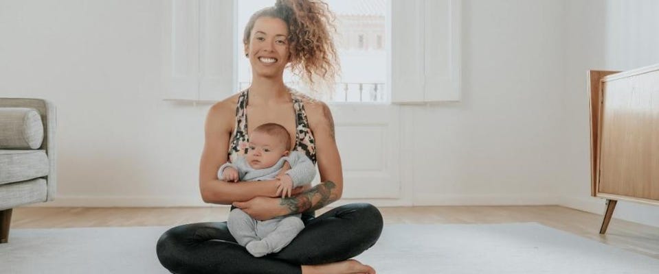 Mom sitting in yoga pose with baby