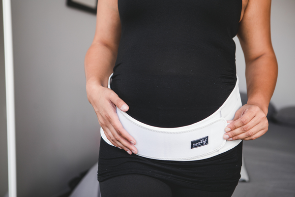 Pregnant mother wearing Motif Medical's Pregnancy Back Brace