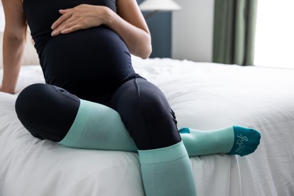 pregnant mom wearing Motif Medical Teal Compression Socks for releif for pregnancy swelling