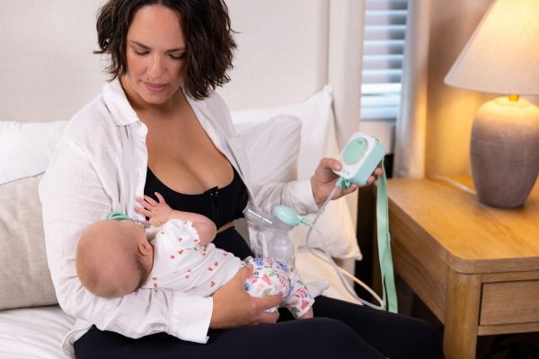 Breastfeeding mom using the motif roam with breastshields