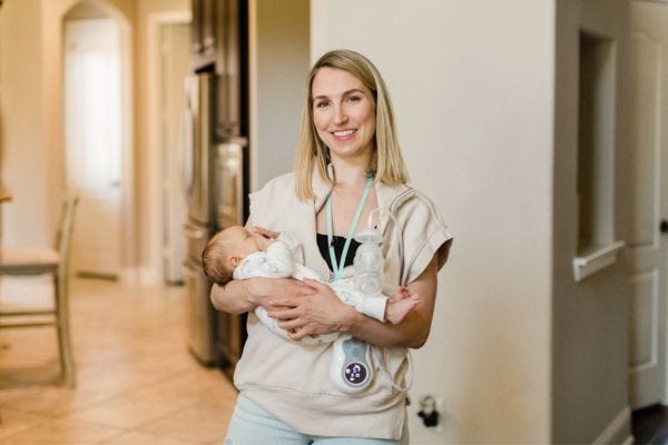 breastfeeding mom holding her baby with the motif duo breast pump around her neck